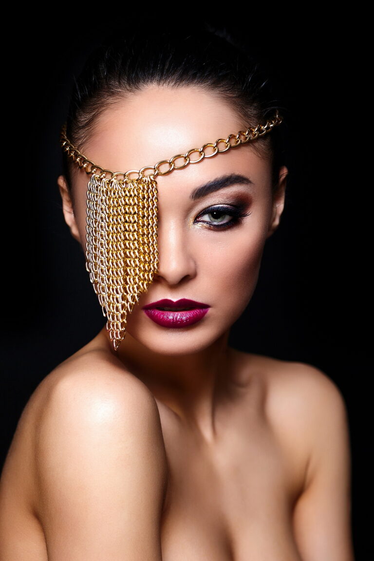 High fashion look.glamor closeup portrait of beautiful sexy Caucasian young woman model with colorful lips,bright makeup, with perfect clean skin with jewelery on eye isolated on black